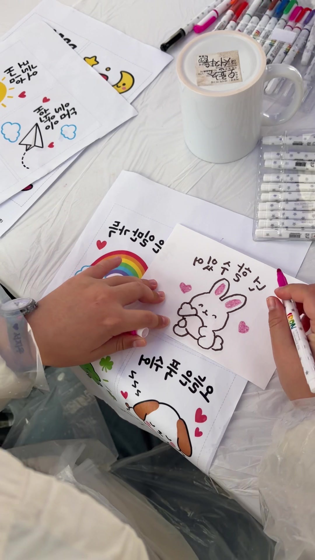 A child drawing a design for a custom mug